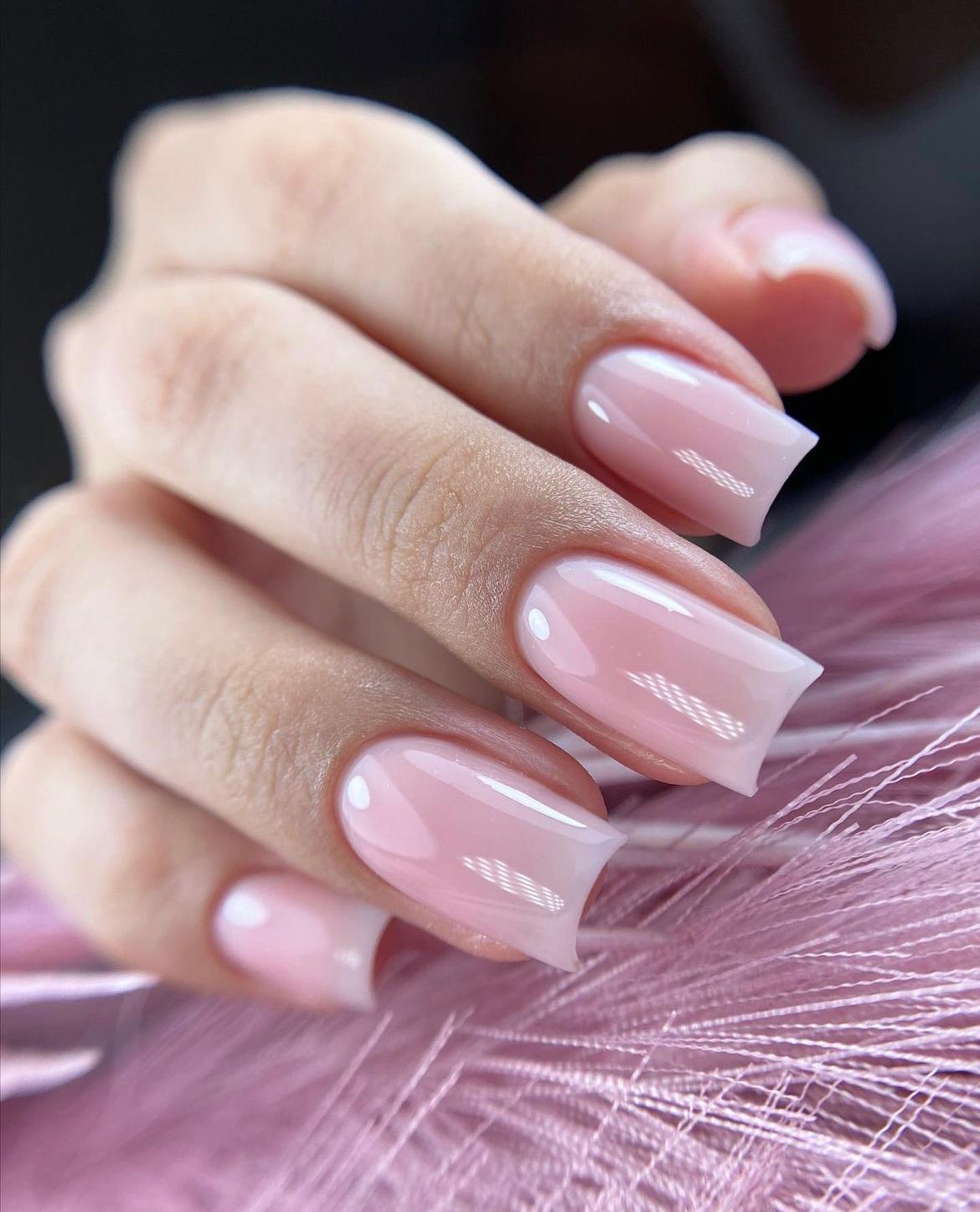 Detalle manicura de uñas color rosáceo